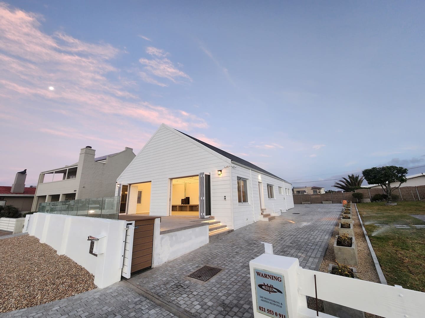 Completed white gabled beach house in Melkbosstrand photographed at sunset from the driveway